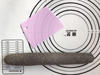 12、黑芝麻牛奶刀切,取出面团在垫子上排气，重新揉至光滑，滚成长条状
