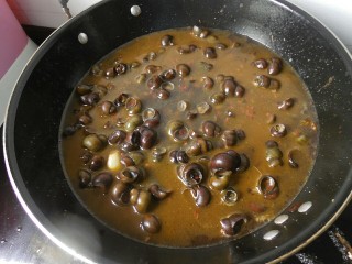 12、香辣螺蛳,炒至白糖和盐融化后,在锅内倒入水,水一定要多,因为螺蛳烧到后面要留有一点汤汁才好吃。然后中火闷煮10来分钟即可。切记不能把汤汁给烧干了啊,烧到后面发现汤汁还剩有一小半的时候,就可以关火了