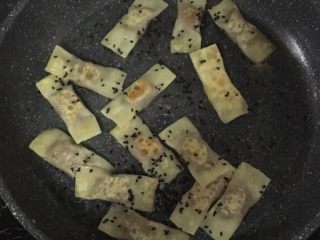 13、宝宝煎饺,翻面，撒上少许芝麻（芝麻可以不放），煎至金黄色后，加入水淹过饺子的一半，盖上盖子煮会