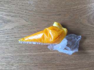 14、婴儿辅食之南瓜米糊,搅拌好后关闭电源，取出搅拌杯，将南瓜泥倒入到裱花袋里，顶端剪一个小口；
