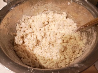 2、小油饼卷饼,一点点加入开水,用筷子搅拌成颗粒状。