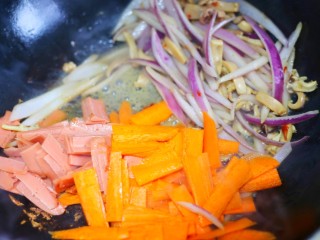 6、墨鱼杂蔬炒螺丝意面,加入胡萝卜、火腿继续翻炒。