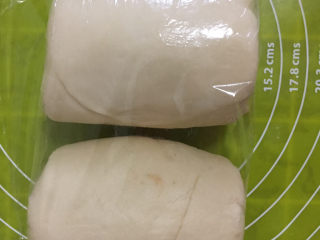 14、红豆酥,沿一边卷起，盖保鲜膜后松弛10-15分钟