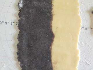 5、玻璃心杂粮饼干,冷藏好的面团拿出来，硅胶垫上撒少许手粉，将面块面团并排擀开，这样擀出来的面片一半是黑色，一半是黄色