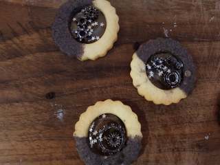 12、玻璃心杂粮饼干,拿一片玻璃心的饼干，中间放上齿轮巧克力，然后撒几片可食用银色小星星