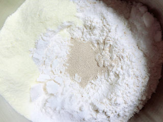 1、水果披萨,首先我们先和面。牛奶、奶粉、鸡蛋、面粉、黄油、酵母、盐。面和好了,盖上保鲜膜发酵30分钟