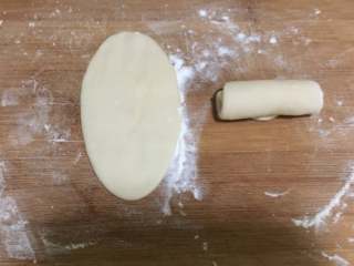 11、蛋黄豆沙酥,之后,我们取一份做好的,用擀面杖擀成牛舌状。再自上而下卷起来。