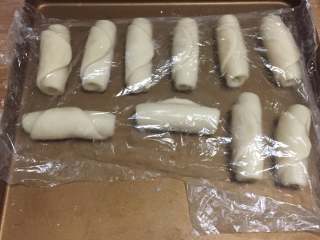 12、蛋黄豆沙酥,按照上述的方法做好全部的之后我们继续将它们表面盖上保鲜膜,进行松弛。