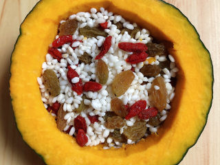 9、糯米南瓜盅,再放入枸杞子和葡萄干,将米粒与之搅拌均匀。