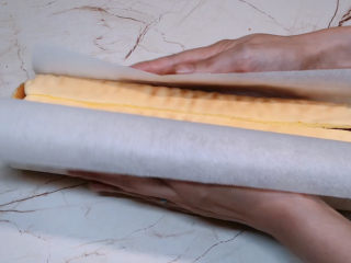 15、虎皮蛋糕卷,双手提起油纸包在表面，然后就可以切开吃了