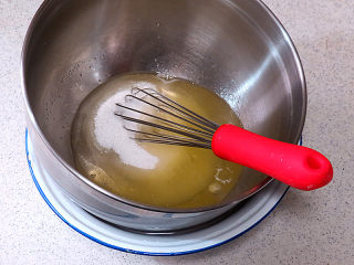 3、小嶋老师的经典费南雪蛋糕,面糊制做:细砂糖跟蛋白一起,隔水加热至手温(约38℃)取出,用打蛋器搅拌均匀,注意不要将蛋白打发,蛋白打散打断筋络就行,打蛋器要始终紧贴蛋盆的底部并进行操作,这样会避免空气进入。只要将细砂糖溶化即可,也不要加热过度