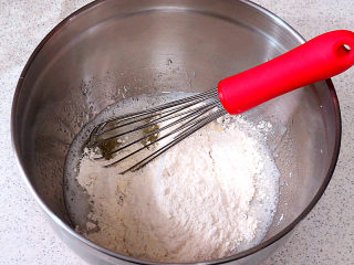 5、小嶋老师的经典费南雪蛋糕,低粉和细杏仁粉混合均匀,过筛。将混合过筛的低粉和杏仁粉加入蛋白混合液中,用手动打蛋器充分搅拌顺滑。