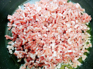 9、梅干菜肉包,锅中倒入油，加热至五成热，放入肉馅翻炒均匀。