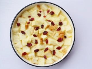 9、酥脆软滑的蛋奶吐司布丁,最后在表面撒上蔓越莓干。