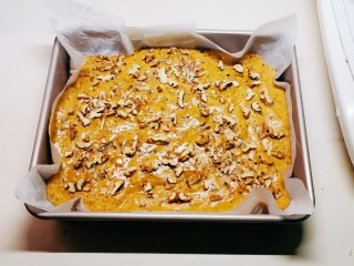 13、核桃红枣糕,将红枣糊倒入烤盘中，震出气泡，均匀撒上核桃碎。