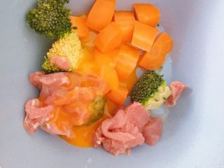 4、胡萝卜西兰花蛋黄猪肉小馄饨,所有食材放入碗中,加一个蛋黄(这里鸡蛋我只取蛋黄,对蛋清不过敏的宝宝可以直接加全蛋)