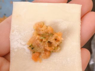 11、胡萝卜西兰花蛋黄猪肉小馄饨,第二种包法:取适量馅料放在饺子皮上(同样的不要太多哦),然后在上面空白部分沾一点清水