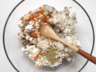 6、黄金蔬菜米糕,加入豆腐丁、2个鸡蛋清、虾皮粉、黑芝麻牡蛎粉，将混合的好的饭菜用勺子搅打2分钟，将蛋清搅打的蓬松一点。 也可以加入少许玉米淀粉，能更好的帮助凝固。