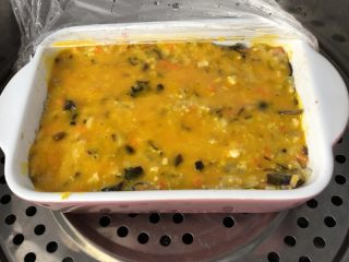 11、黄金蔬菜米糕,取出来刷一层蛋黄液，继续盖保鲜膜蒸15分钟。具体蒸的时间根据食材量来调整