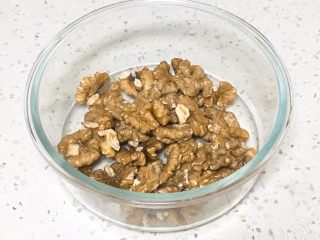 1、核桃酥,核桃仁放烤箱烤熟,冷却后放入玻璃碗中。