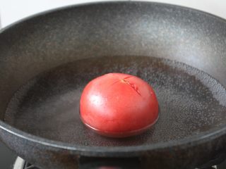 4、番茄鹅蛋炒豌豆卷心菜,将番茄先用刀划一个十字口,放在开水里汆烫一下,然后看出来,过一下凉水,这时番茄皮会裂开,能很容易的把皮剥下来。