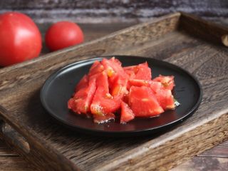 5、番茄鹅蛋炒豌豆卷心菜,将剥了皮的番茄切成小块。