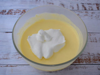 13、酸奶芝士蛋糕,把三分之一蛋白倒入奶酪糊中拌匀