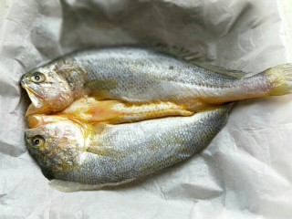 2、孜然烤鱼,去掉包装，将黄花鱼清洗干净，淋干水份。放在垫有油纸的烤盘中。