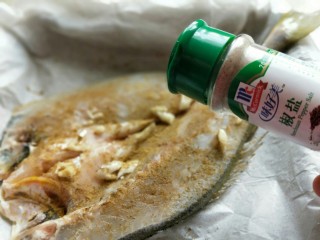 7、孜然烤鱼,黄花鱼两面再撒上椒盐粉。