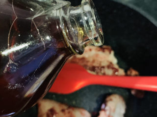 8、砂锅炖羊肉,倒入1勺料酒,继续炒香羊肉;