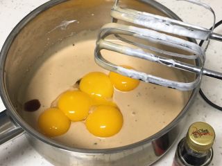 7、酸奶咖啡蛋糕,加入蛋黄和香草精，也用打蛋器搅拌至顺滑。