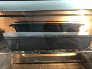 18、绿豆馅饼,烤箱预热好，进烤箱前，在饼子上铺上另一层油脂，放上一个模具，这样是为了让饼子在烤制的过程中，更好的定型。按上下火150度，烤25分钟