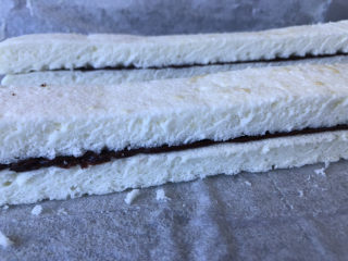 23、巧克力白玉卷,再把另一条没有巧克力酱的蛋糕胚重叠在一起，按压整齐。