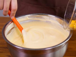 11、【免烤箱蛋糕】零失败芒果慕斯蛋糕,在慕斯液中加入切成小丁的芒果颗粒。