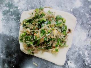 7、韭菜粉条薄饼,然后擀成中间厚两边薄的皮，放入馅料