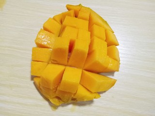 7、#冬喝暖饮夏吃冰#健康低卡-芒果酸奶昔,芒果洗干净,从中间切开,再果肉上划几刀,如图。
