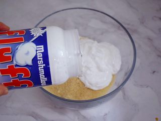 5、可可费南雪,粉类加入Fluff棉花糖，用手动打蛋器混合均匀，如果太粘可借助刮刀拌匀，将配方的糖粉全换成Fluff棉花糖，因Fluff棉花糖口感绵软，甜而不腻，这款费南雪加入了Fluff棉花糖和坚果类，不但颜值提升了，口感层次也更为丰富，吃起来Q弹，有嚼劲。给予味蕾一种全新的体验，让人欲罢不能！