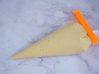 8、可可费南雪,将制作好的面糊装入裱花袋中