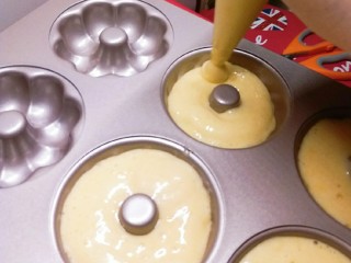 10、圈圈小蛋糕,在裱花袋顶端剪掉一个小角 形成开口 将面糊挤入模具中 不要挤满