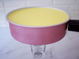 16、寿星公芒果慕斯蛋糕(十寸),取出已经凝固的慕斯蛋糕,底部用杯子垫上,再用用吹风机对着模具四周吹一吹