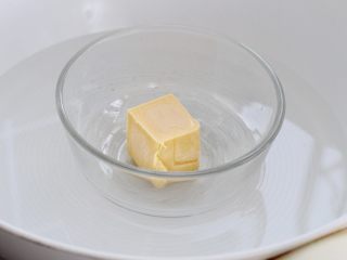 1、万圣节蜘蛛杯子蛋糕,将黄油放进容器中隔水融化成液态，或者用微波炉加热融化，放置一旁冷却备用