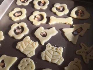 9、玻璃糖饼干,将按压好的饼干摆放在不粘烤盘里，中间空的部分放上硬糖碎，