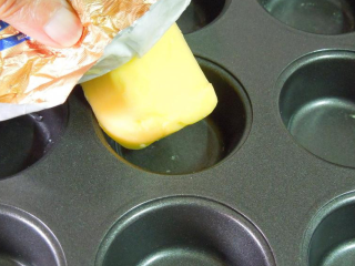 2、缤纷花杯~年菜,准备小型马芬杯模，以奶油涂抹内壁，使馄饨皮不沾黏。