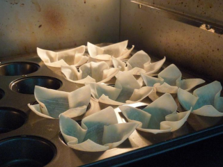 4、缤纷花杯~年菜,放入预热好的烤箱，以摄氏180度烤8-9分钟。注意花瓣顏色出现金黄烤色时，就可以出炉。放置一旁备用。