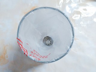 8、鲜草莓，蓝莓溶豆,准备好一个八齿裱花嘴和一个裱花袋，装入一个较高的杯子里！以便拌好的蛋白可以很快放入裱花袋里，进行挤花！