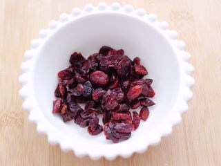 4、粉嫩蔓越莓果仁芝麻饼,把蔓越莓放入碗里。