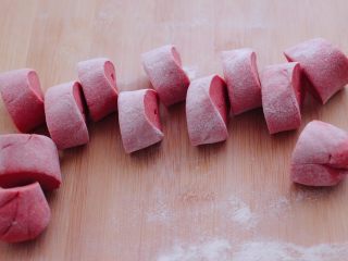 9、粉嫩蔓越莓果仁芝麻饼,把醒发好的面团排气揉匀后，用手搓成长条，用刀切成大小一致的剂子。