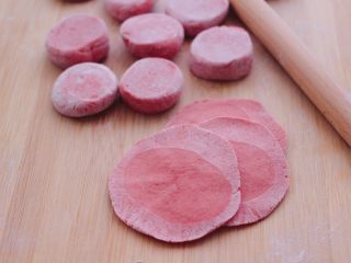 10、粉嫩蔓越莓果仁芝麻饼,把剂子摁扁后，用擀面杖擀成圆形薄面皮。