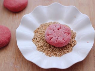 13、粉嫩蔓越莓果仁芝麻饼,把没有花纹的一面，蘸上一层薄薄的白芝麻。
