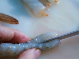 5、宝宝脆皮虾,用刀把虾从中间处切开,注意不要全部切断,留一点